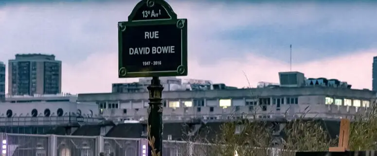 If you stroll down David Bowie Street, which city’s sights are you enjoying?